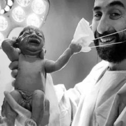 Fotografia anului - Un nou-născut îi smulge masca de protecție medicului: "Un semnal că ne vom da jos în curând măștile"