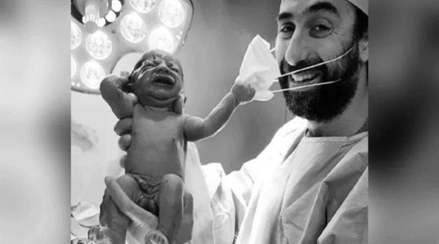Fotografia anului - Un nou-născut îi smulge masca de protecție medicului: "Un semnal că ne vom da jos în curând măștile"