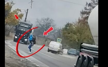 Poliția Română publică o imagine cu o mamă cu copilul în brațe, trecând grăbită printre două TIR-uri