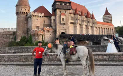 Un chinez care străbate Europa călare s-a fotografiat la Castelul Corvinilor, în Hunedoara, în mijlocul unei ședințe foto de la o nuntă