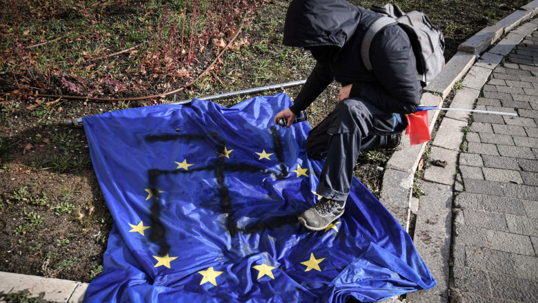 Un protestatar AUR a desenat o svastică pe drapelul Uniunii Europene. Fotografia, preluată de marile agenții
